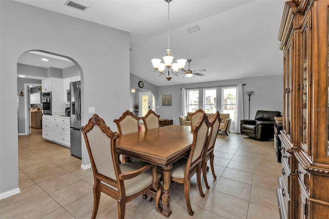 tiled dining room featuring a chandelier and vaulted ceiling