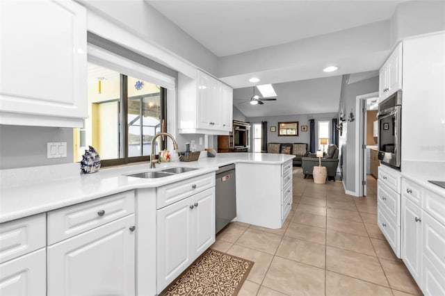 kitchen featuring appliances with stainless steel finishes, white cabinets, sink, kitchen peninsula, and light tile patterned flooring