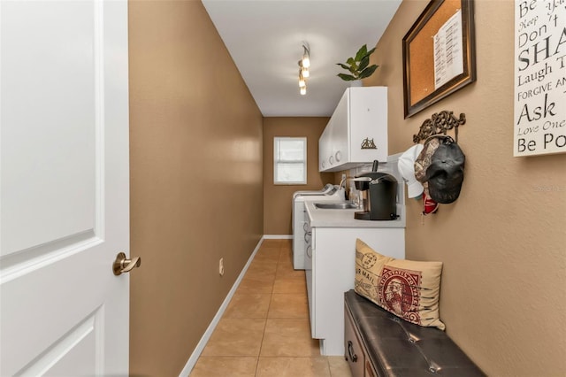 laundry room with sink, washing machine and clothes dryer, cabinets, and light tile patterned flooring