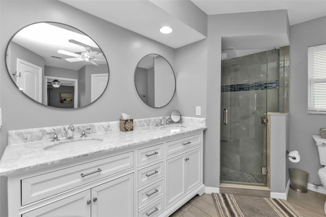 bathroom with toilet, a shower with shower door, ceiling fan, and vanity