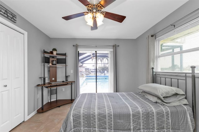 bedroom with ceiling fan, access to exterior, tile patterned floors, and a closet