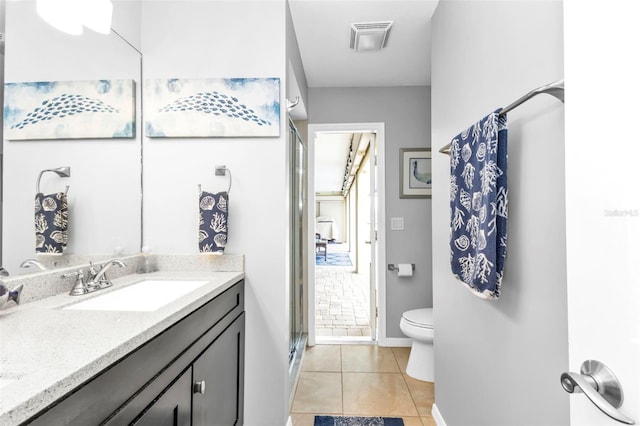 bathroom with toilet, a shower with shower door, tile patterned floors, and vanity