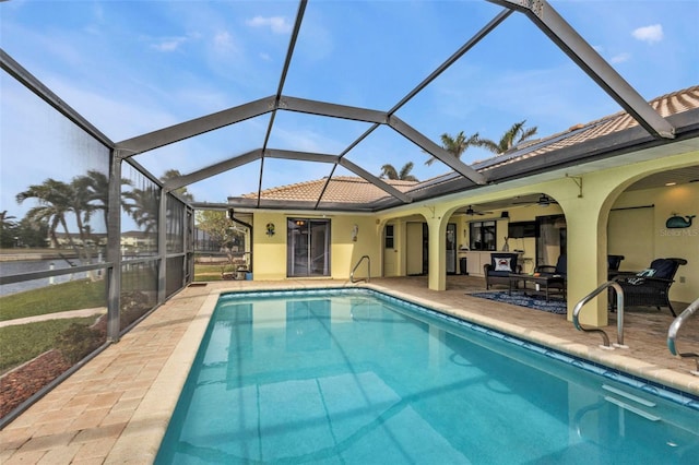 view of swimming pool with ceiling fan, a patio area, a lanai, and a water view