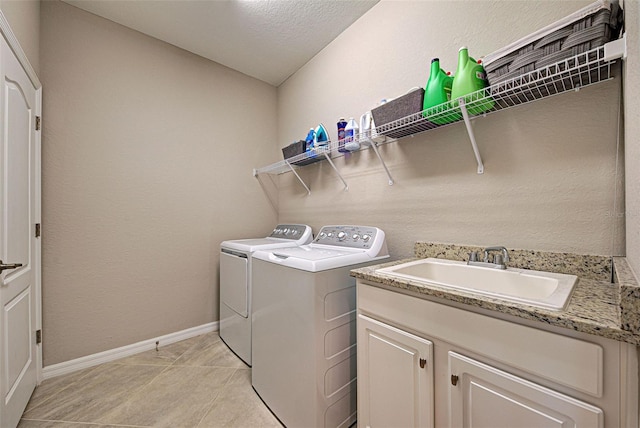 washroom with independent washer and dryer, light tile patterned floors, and sink