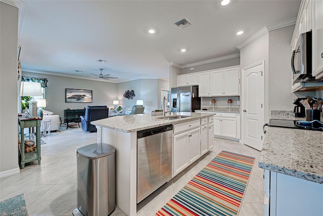 kitchen with stainless steel appliances, light stone countertops, white cabinets, crown molding, and a kitchen island with sink