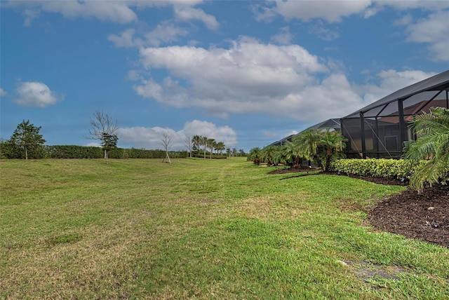 view of yard with a rural view and glass enclosure