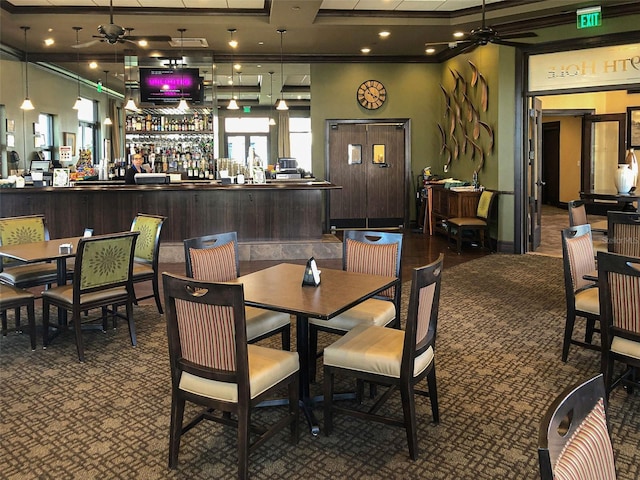 dining area with ornamental molding, ceiling fan, plenty of natural light, and bar