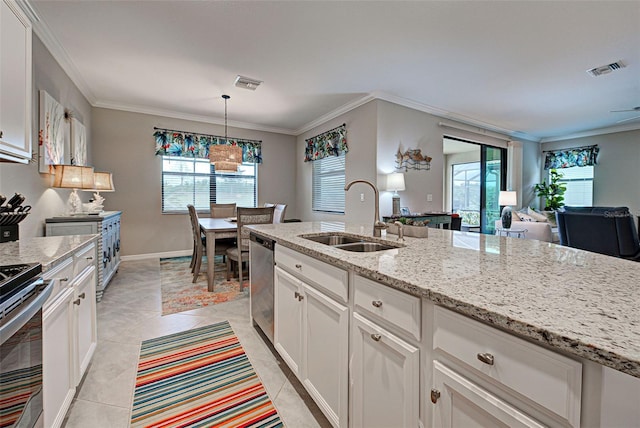 kitchen with sink, light stone counters, stainless steel appliances, white cabinets, and hanging light fixtures