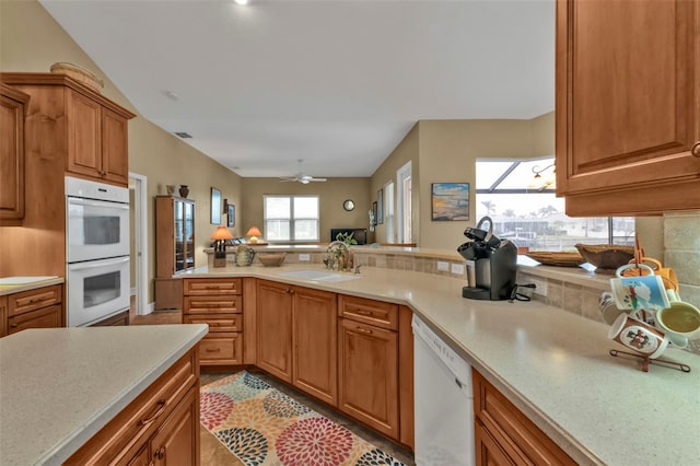 kitchen featuring tasteful backsplash, sink, ceiling fan, kitchen peninsula, and white appliances