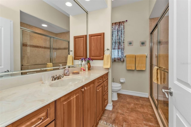 bathroom with vanity, a shower with shower door, and toilet