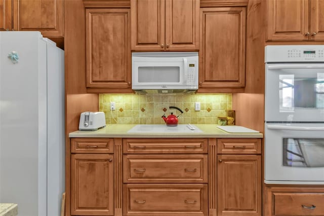 kitchen featuring white appliances and decorative backsplash