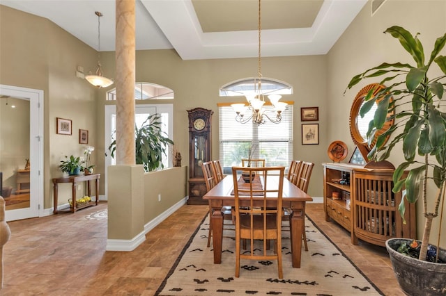 dining space with a raised ceiling and a notable chandelier