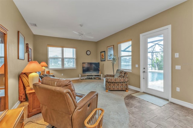 living room with ceiling fan and a healthy amount of sunlight