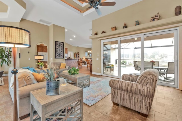 living room with a towering ceiling and ceiling fan