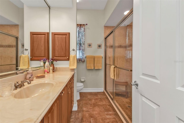 bathroom with an enclosed shower, vanity, and toilet