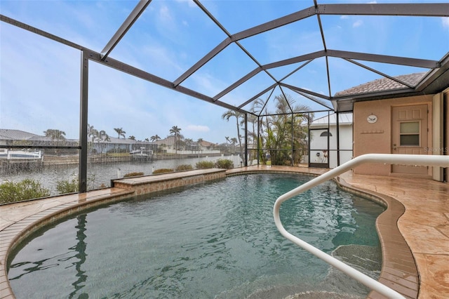 view of swimming pool with a lanai, a patio, and a water view