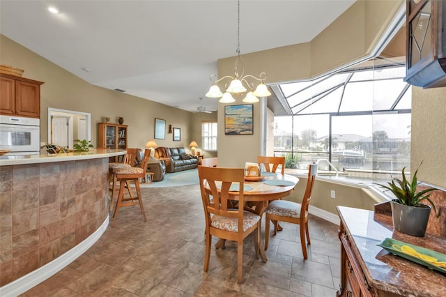 dining room with vaulted ceiling and a notable chandelier