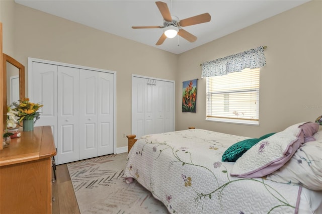 bedroom featuring ceiling fan and two closets