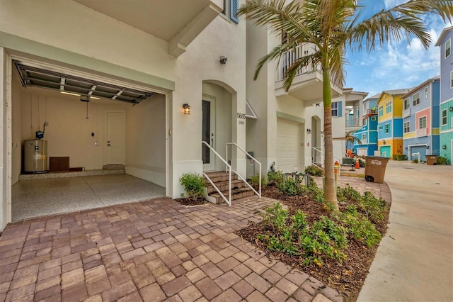 doorway to property featuring water heater and a garage