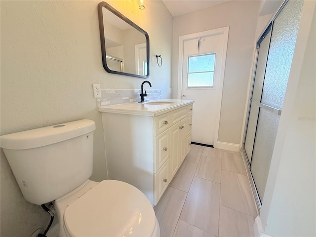 full bath featuring a stall shower, vanity, and toilet