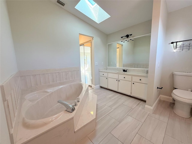 bathroom featuring toilet, a shower stall, vanity, vaulted ceiling with skylight, and a bath