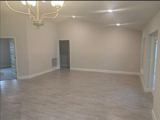 4063 Conestoga St, Port Charlotte, FL 33948 - empty room featuring lofted ceiling, a chandelier, and light wood-style flooring