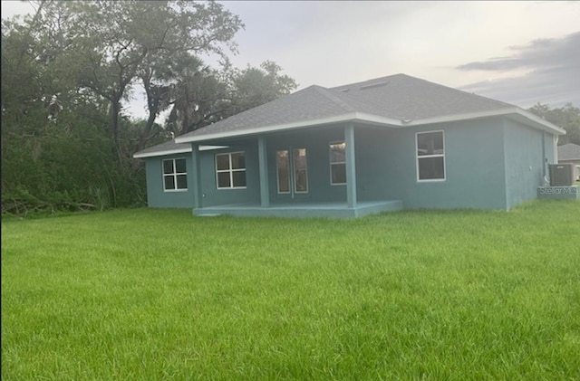 4063 Conestoga St, Port Charlotte, FL 33948 - rear view of property featuring a yard and stucco siding