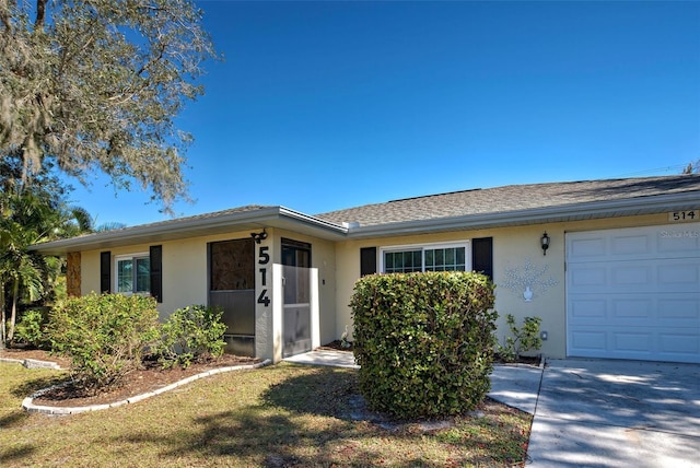 single story home featuring a garage and a front lawn