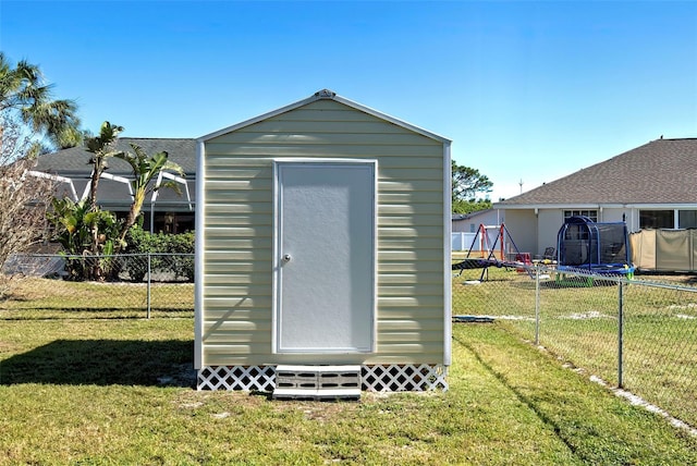 view of outbuilding with a trampoline and a lawn