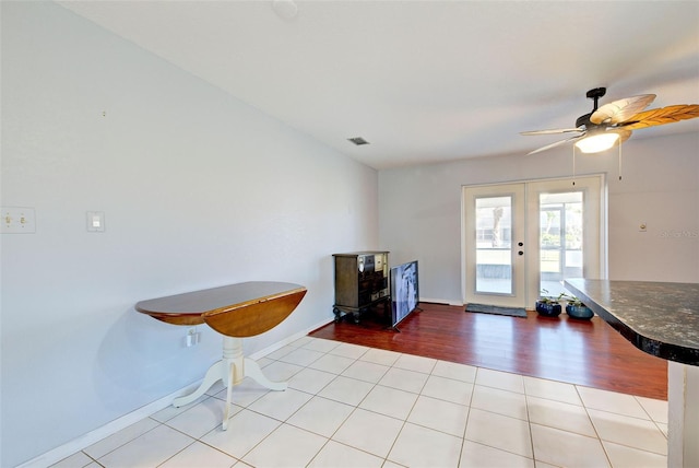 interior space with light tile patterned floors, french doors, and ceiling fan