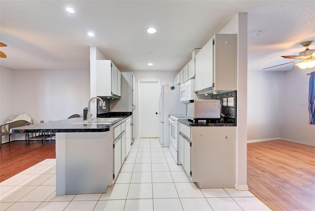 kitchen with white cabinetry, light tile patterned floors, white appliances, and sink