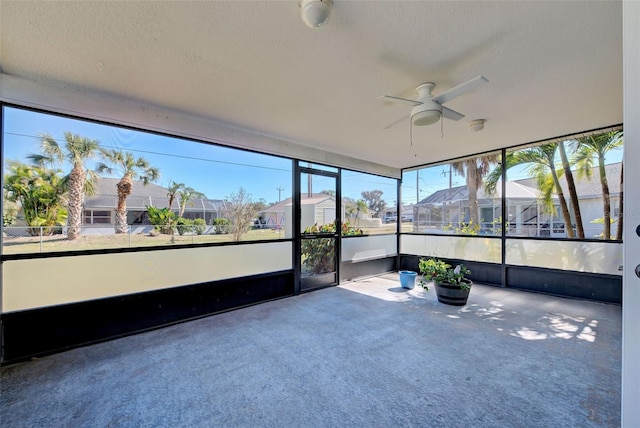 unfurnished sunroom featuring ceiling fan