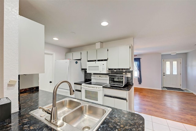 kitchen with sink, light tile patterned floors, white cabinets, white appliances, and backsplash