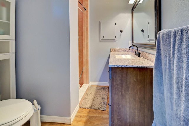 bathroom featuring vanity, toilet, hardwood / wood-style floors, and a tile shower