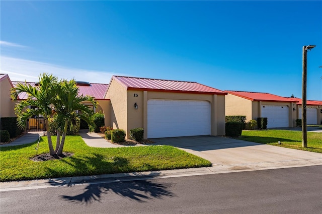 ranch-style house featuring a garage and a front lawn