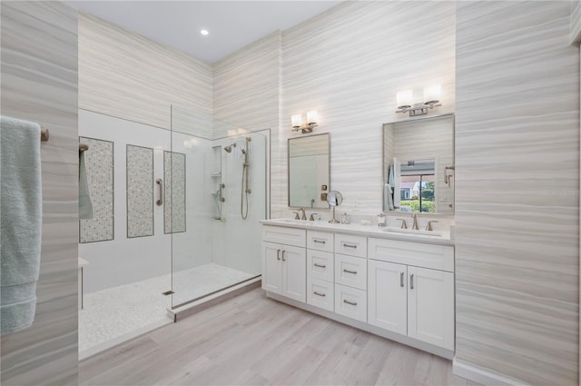 bathroom with vanity, hardwood / wood-style floors, and a tile shower