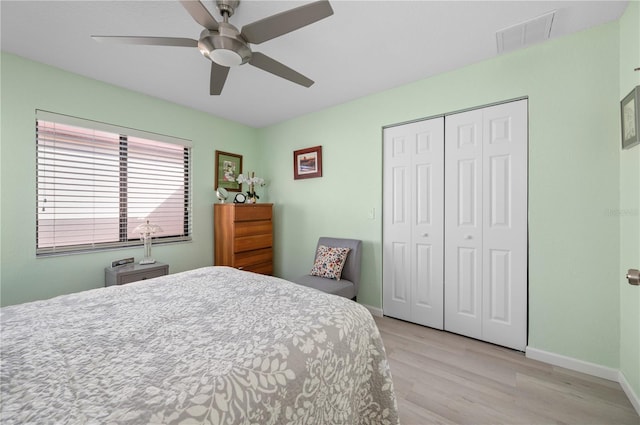 bedroom with light hardwood / wood-style flooring, a closet, and ceiling fan