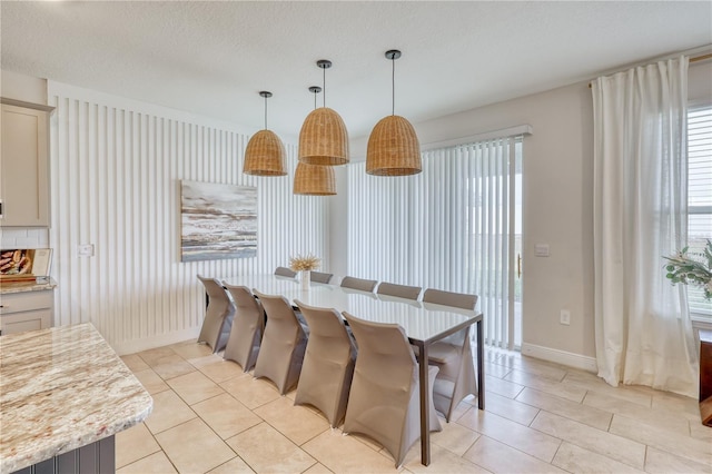 tiled dining space featuring a textured ceiling