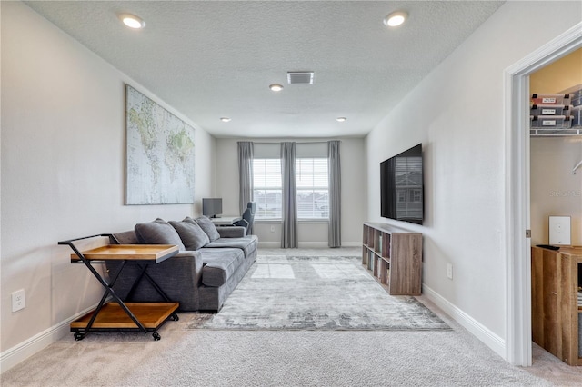 living room with light carpet and a textured ceiling