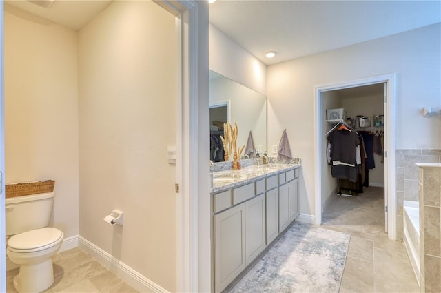 bathroom featuring vanity, toilet, tile patterned flooring, and a washtub