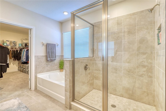 bathroom with tile patterned floors and shower with separate bathtub