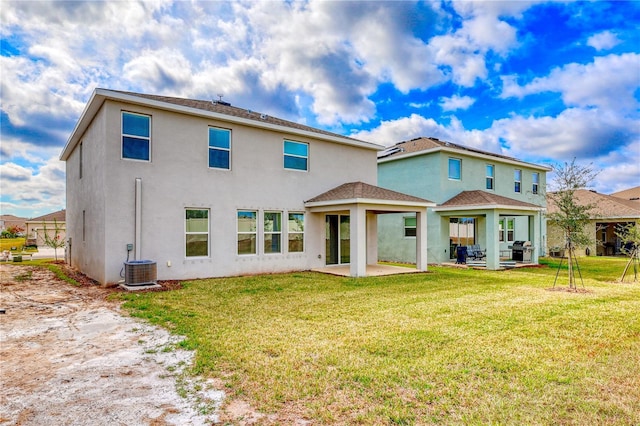 rear view of property featuring cooling unit, a patio, and a lawn