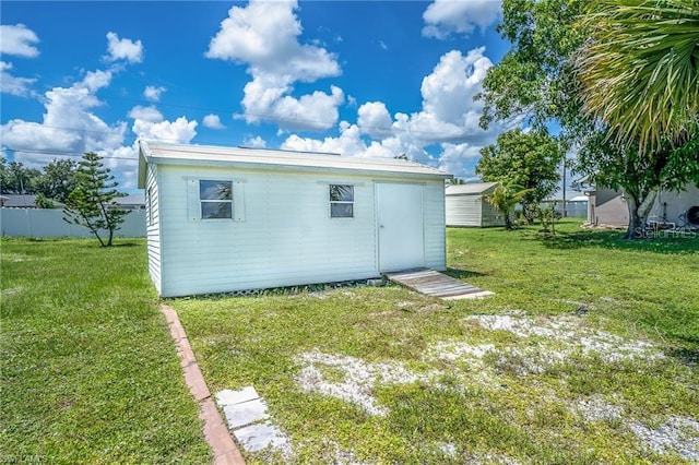 back of property featuring a lawn and a shed