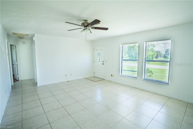 tiled spare room featuring ceiling fan