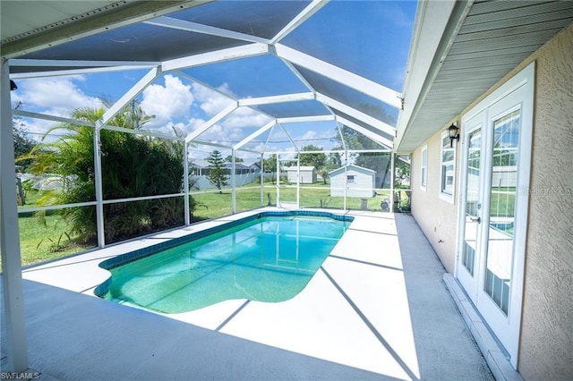 view of swimming pool featuring a lanai, a lawn, and a patio