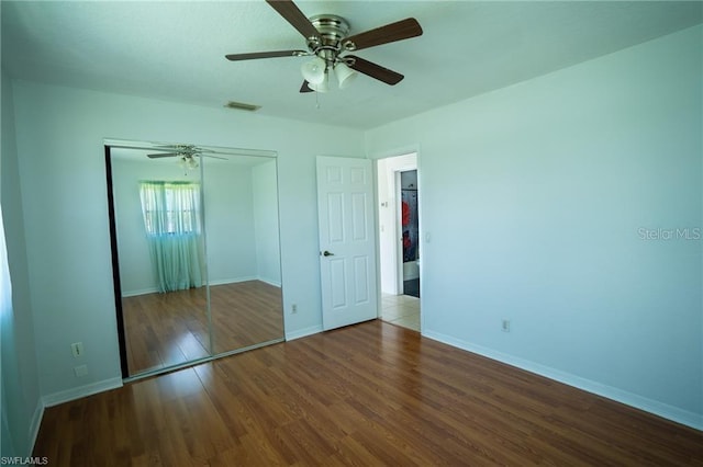 unfurnished bedroom with a closet, ceiling fan, and dark hardwood / wood-style flooring