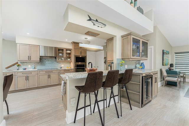 kitchen with tasteful backsplash, wine cooler, stainless steel appliances, light stone countertops, and wall chimney range hood