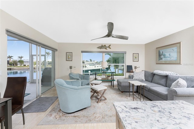 living room featuring a water view, ceiling fan, and light hardwood / wood-style flooring