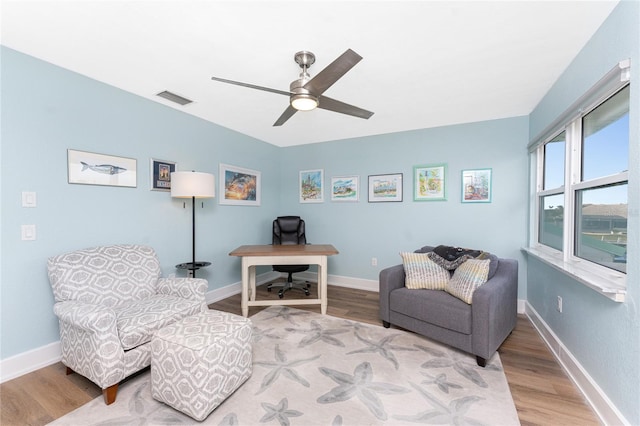 sitting room with ceiling fan and light wood-type flooring