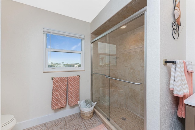 bathroom featuring toilet and a shower with shower door